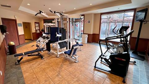Interior view of the fitness center at Sommet des Neiges hotel with weight machines and cardio equipment.