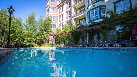 Outdoor swimming pool and lounge area at the Sommet des Neiges hotel at Tremblant Resort during summer.