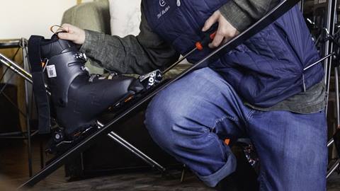 A technician adjusting performance ski bindings with a tool inside a Mont-Tremblant vacation rental.