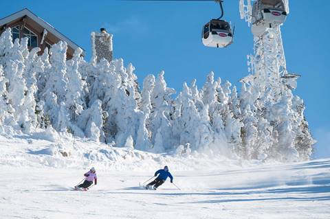 Two skiers at Tremblant making turns on wide open trail