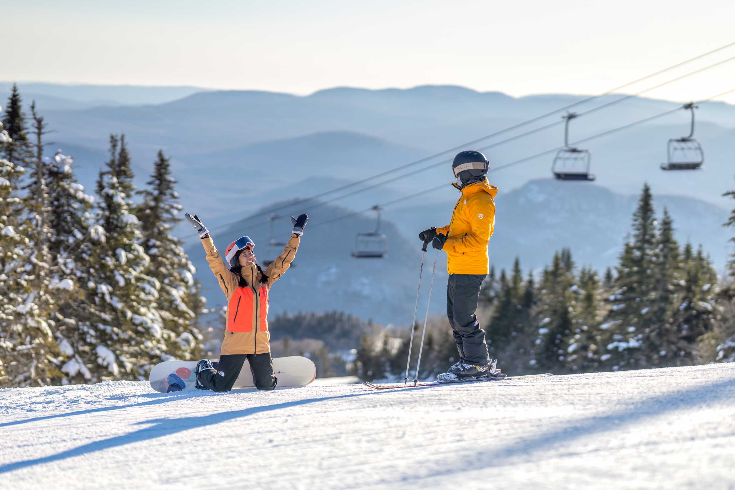 Snowboarder with arms in air, celebrating being first on the mountain at Tremblant 
