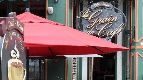 Exterior signage and red patio umbrella at Au Grain de Café bistro in the Mont-Tremblant pedestrian village.